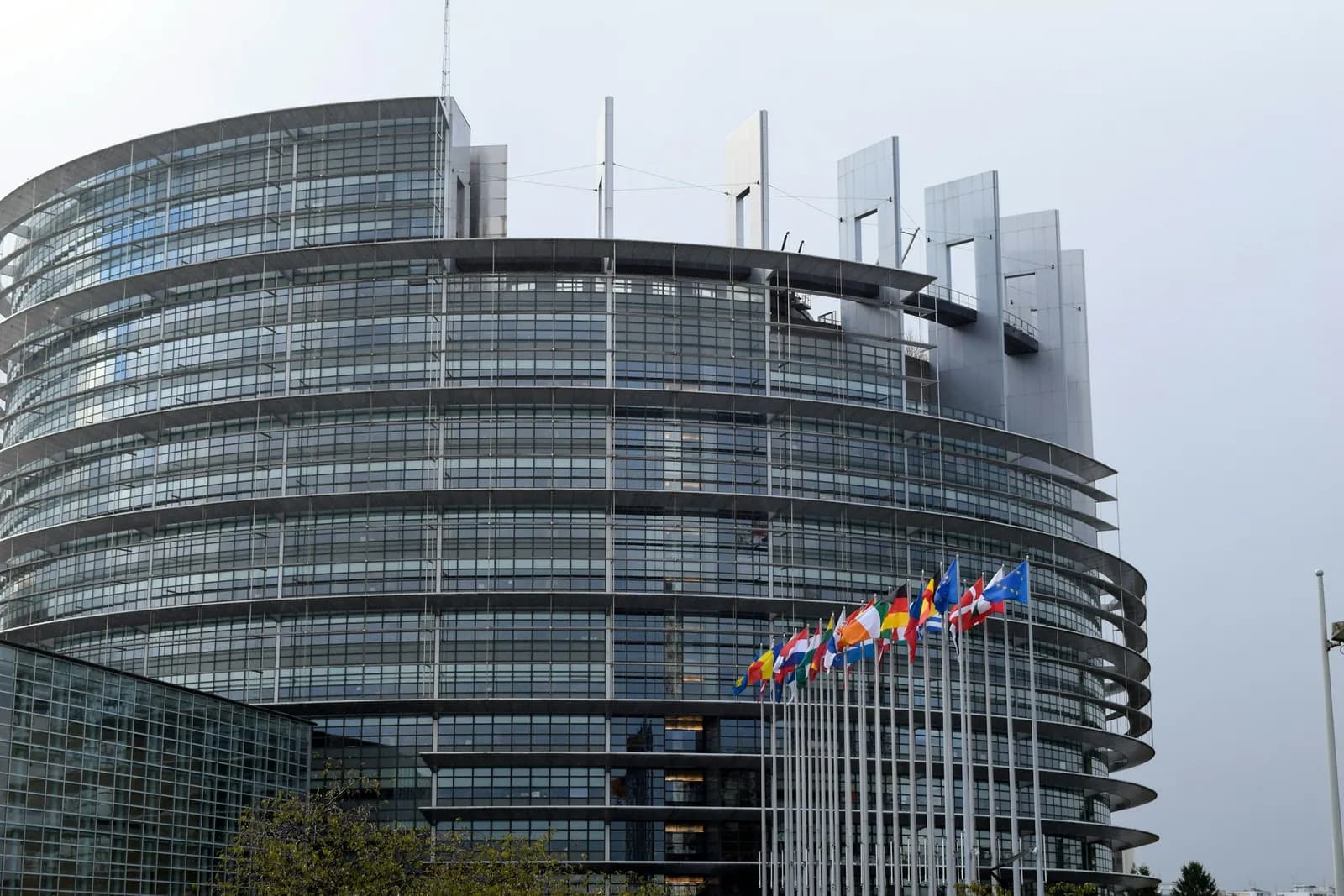 Glass European institution building with EU member state flags flying outside